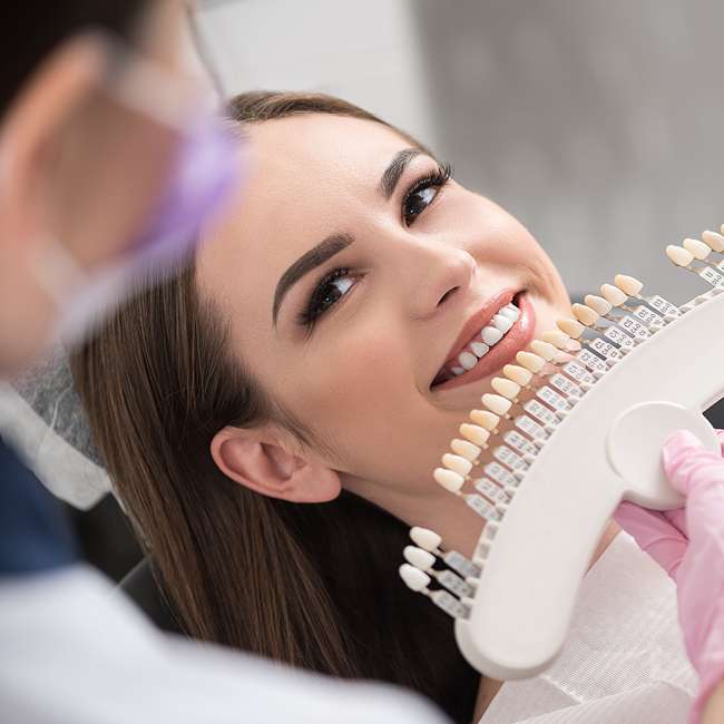 Physician enclosing dental crown to happy lady