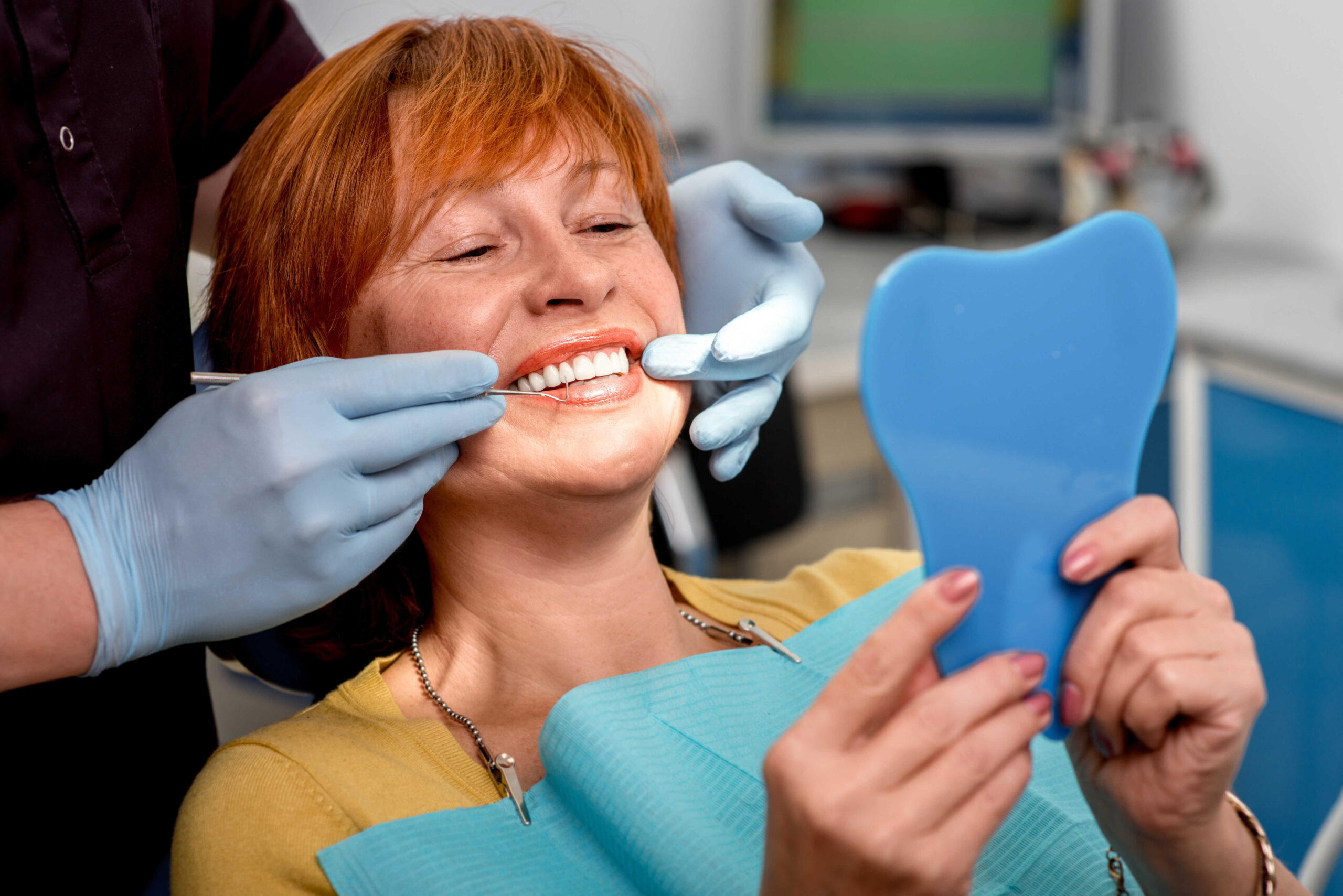 A patient seeing her new dental implants for the first time at Friedman Dental Group's office.